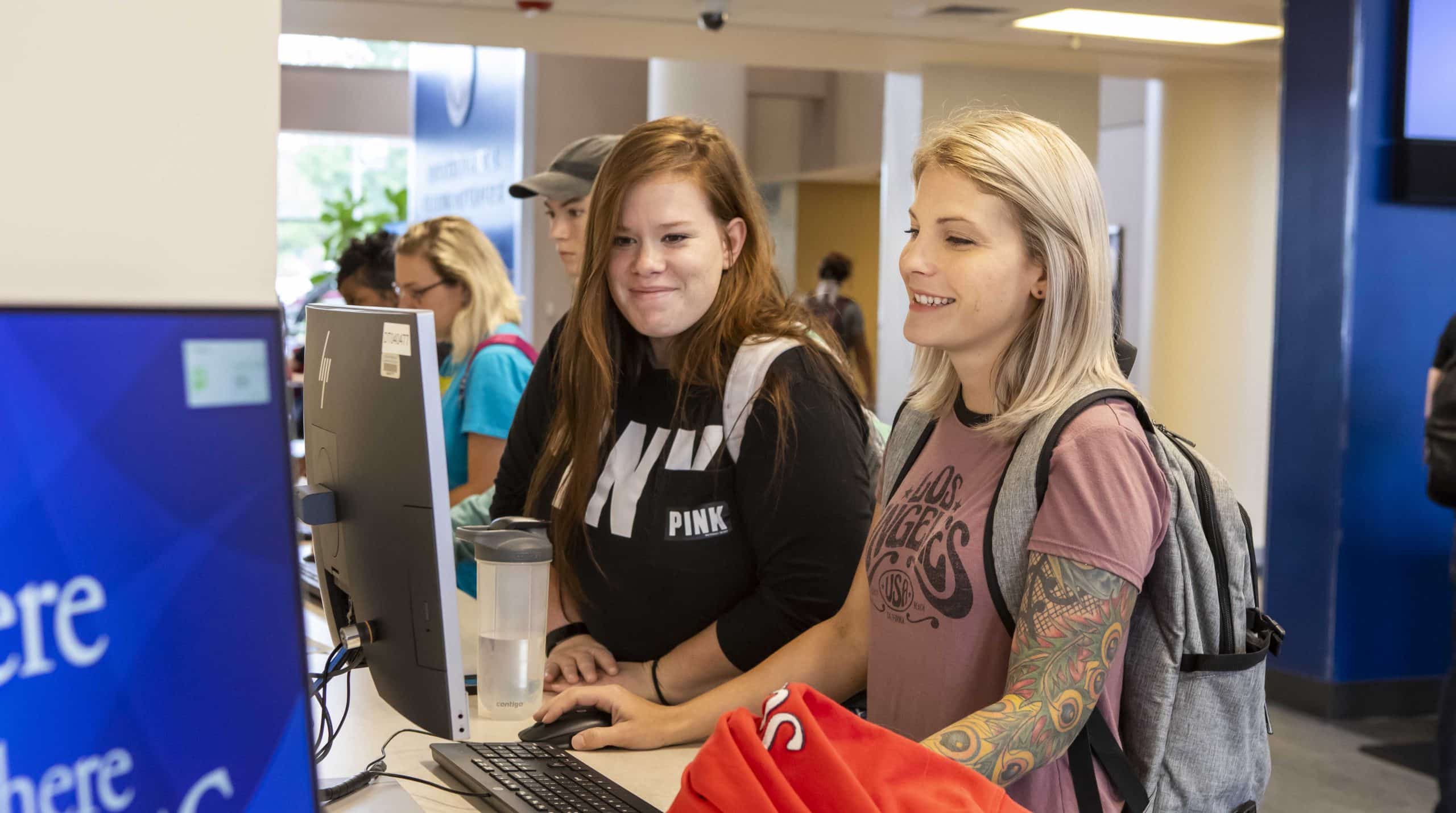 two students at a computer in OTC's welcome center