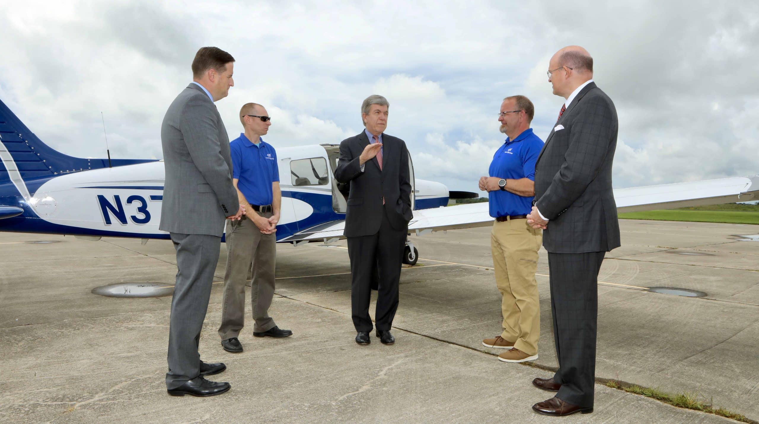 Sen. Roy Blunt stands in front of an OTC plane with OTC officials