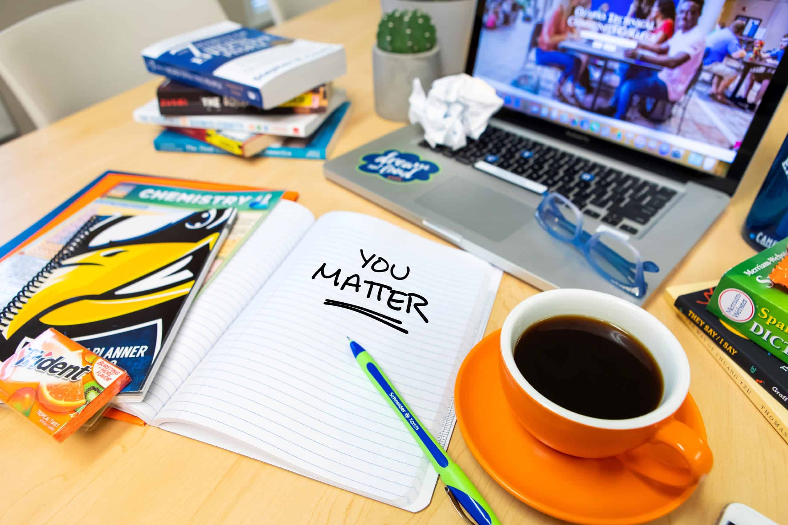 A student's desk with the words "you matter" written on a piece of notebook paper.