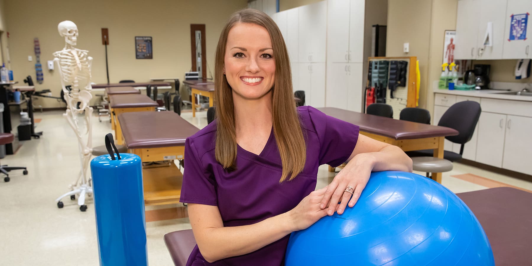 OTC grad Kila Butts poses with an exercise ball in OTC's PTA lab