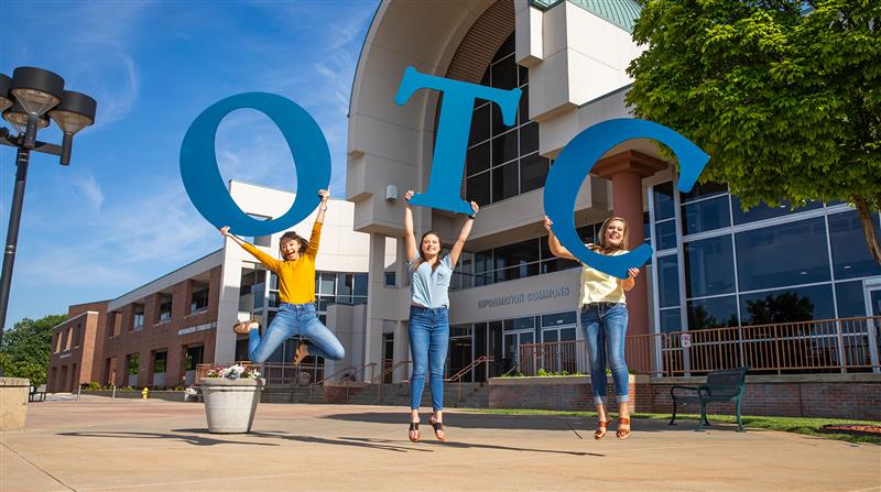 Students jump on plaza holding giant OTC letters